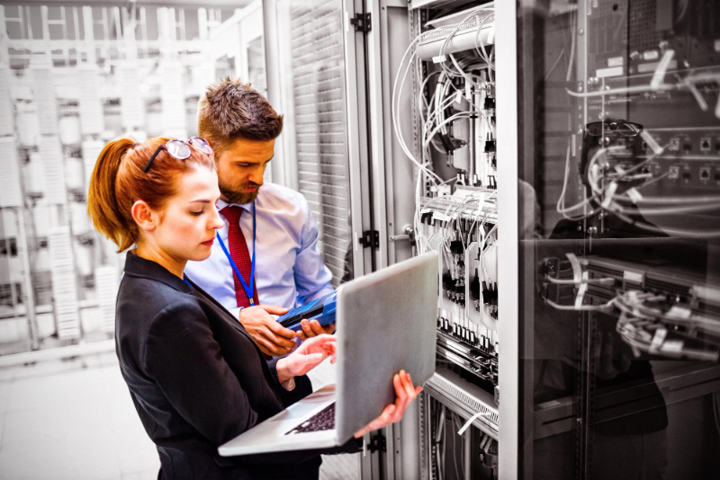 technicians-using-laptop-while-analyzing-server